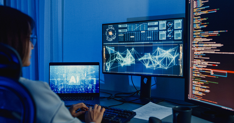 Young Asian woman software developers using computer to write code application program for AI technology at desk with multiple screens work at home office night. Programmer development. Security Software Development