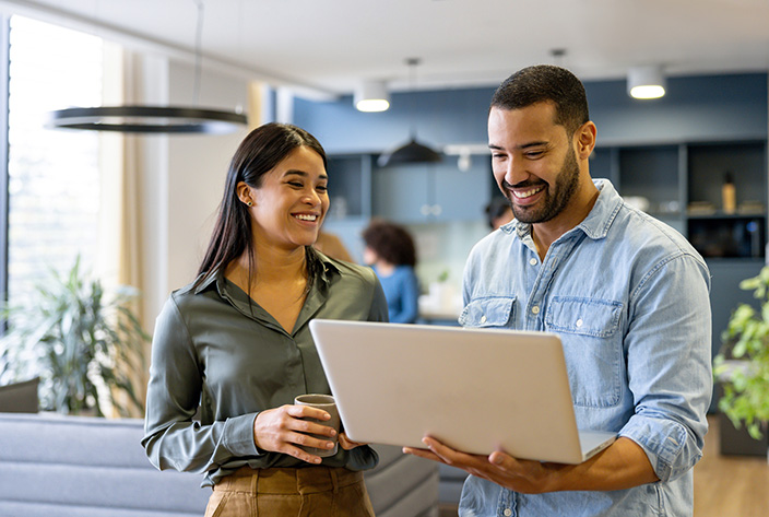 Woman and man reviewing information on a laptop in an office-2147591263 Woman and man reviewing information on a laptop in an office