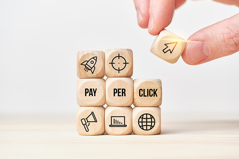 PPC Blocks-1399069506 Blocks with PPC and search realted icons being stacked by a partially out of frame hand